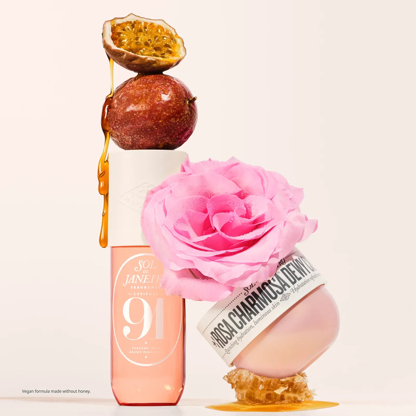 Two cosmetic products with a pink rose and honeycomb on a light background